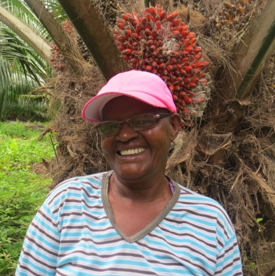 Primer plano de una mujer sonriente con gafas y una gorra rosada.