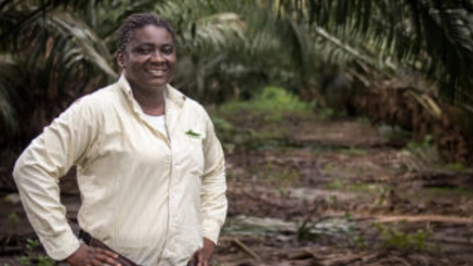 Mujer sonriente de pie en un campo de palmas