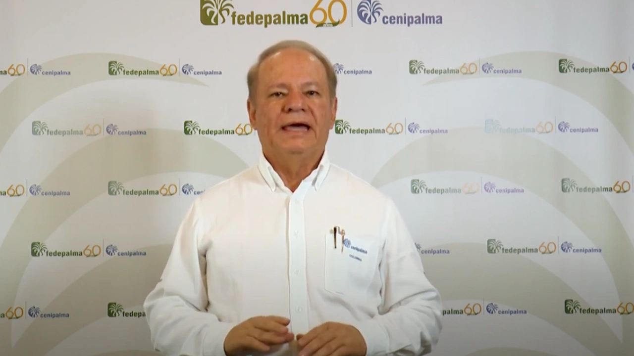 Hombre mayor, hablando frente a un fondo repetido con los logos de Fedepalma 60 años y Cenipalma.