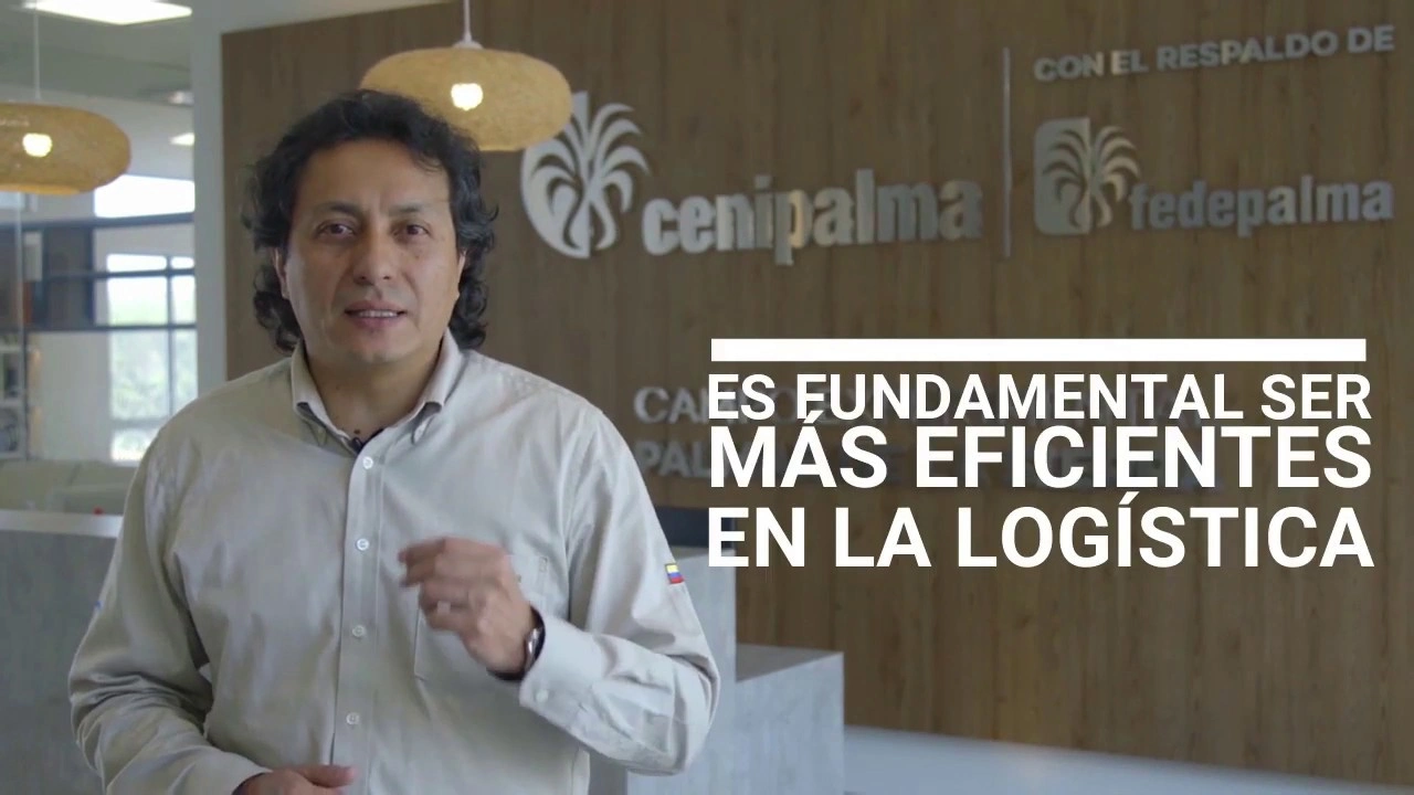 hombre hablando en una oficina moderna con fondo de pared de madera y el texto "ES FUNDAMENTAL SER MÁS EFICIENTES EN LA LOGÍSTICA"