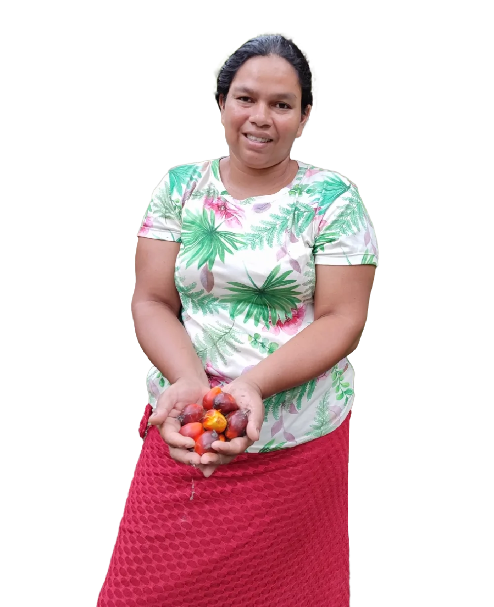 Mujer de mediana edad sonriente sosteniendo un puñado de frutos de palma de aceite.