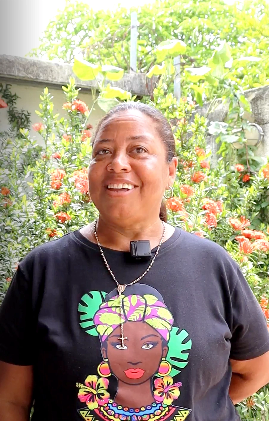 Mujer palmera sonriente de mediana edad con una camiseta negra estampada