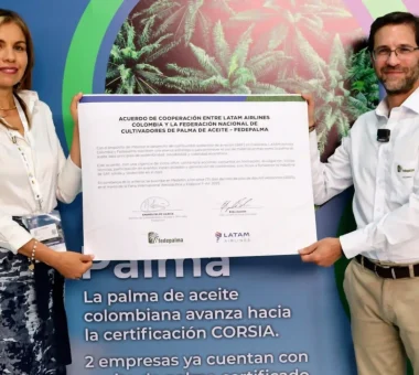 Una mujer y un hombre, sosteniendo un documento de "Acuerdo de Cooperación entre LATAM Airlines Colombia y Fedepalma".